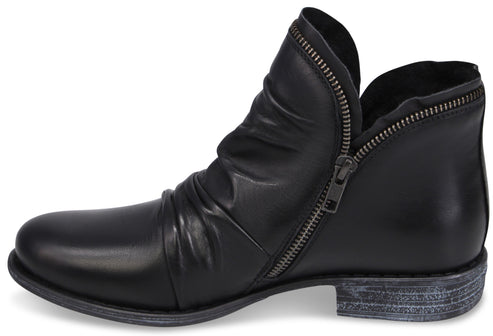 A black leather women's ankle boot with a side zipper, a slouched design on the upper, and a weathered, gray-wash low heel.