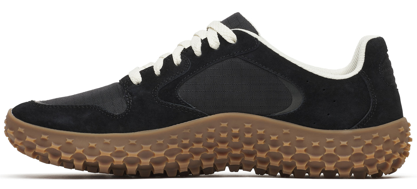 A black sneaker with a brown bumpy sole and white laces.