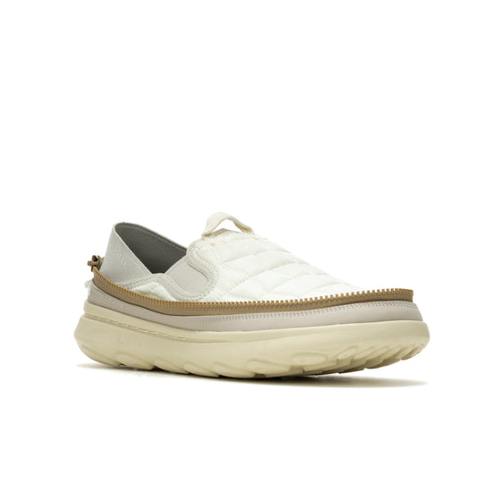 Off-white slip-on sneaker with a quilted upper, a tan-colored trim, and a thick sole.