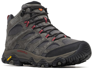 A charcoal grey mid-cut hiking boot with mesh and suede upper, black laces, red eyelet accents, black toe cap, dark grey midsole with Merrell and Vibram logos on the side, and a rugged black tread sole.