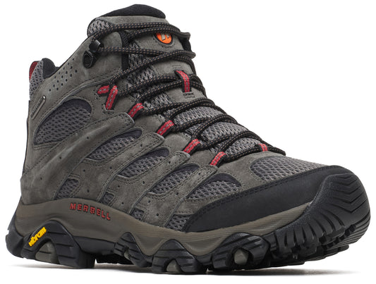 A charcoal grey mid-cut hiking boot with mesh and suede upper, black laces, red eyelet accents, black toe cap, dark grey midsole with Merrell and Vibram logos on the side, and a rugged black tread sole.