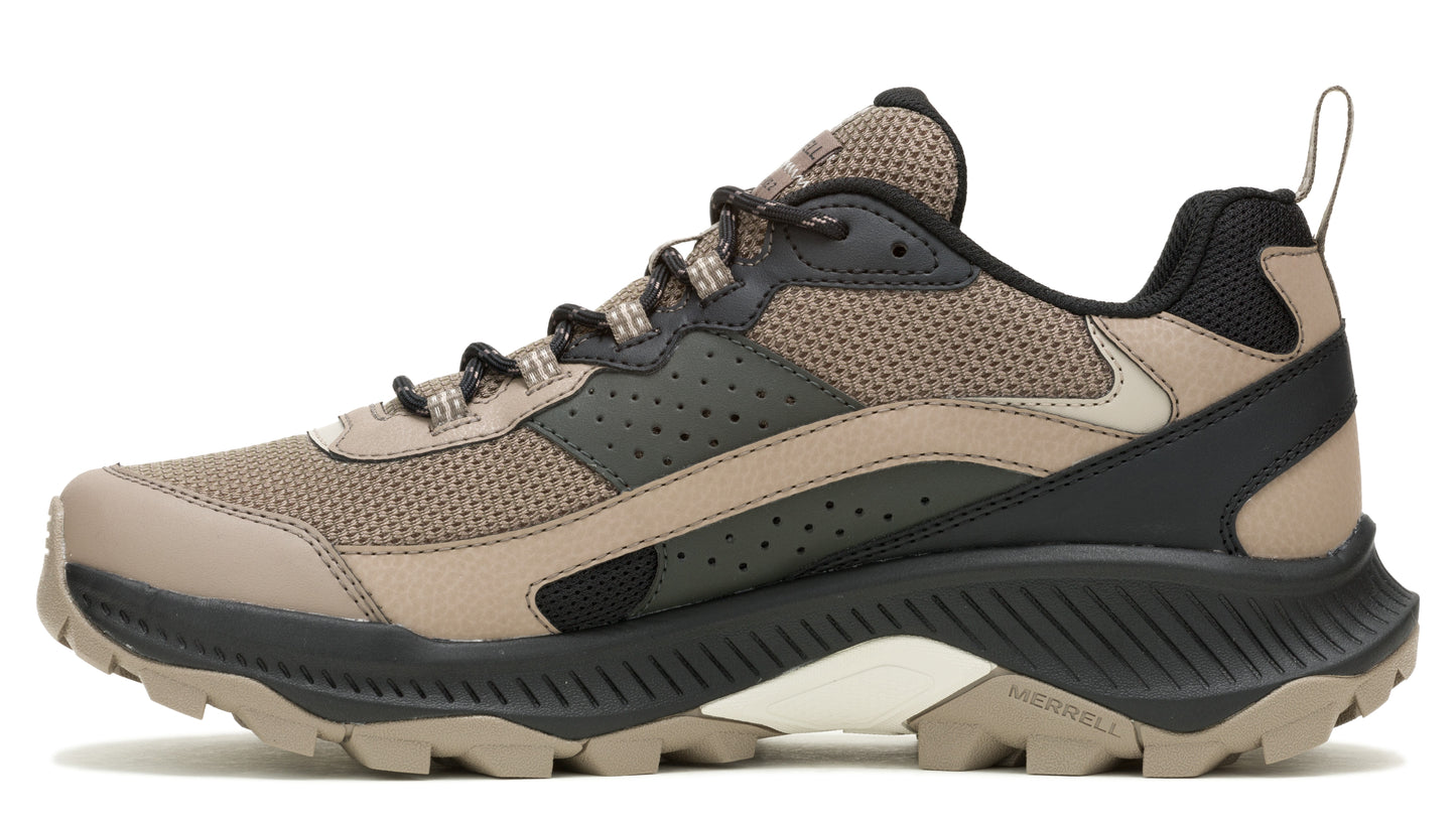 A side view of a brown and black trail shoe with a lug sole.