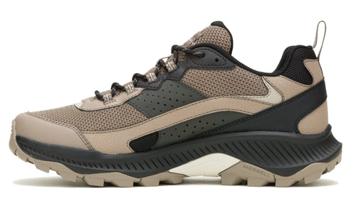 A side view of a brown and black trail shoe with a lug sole.