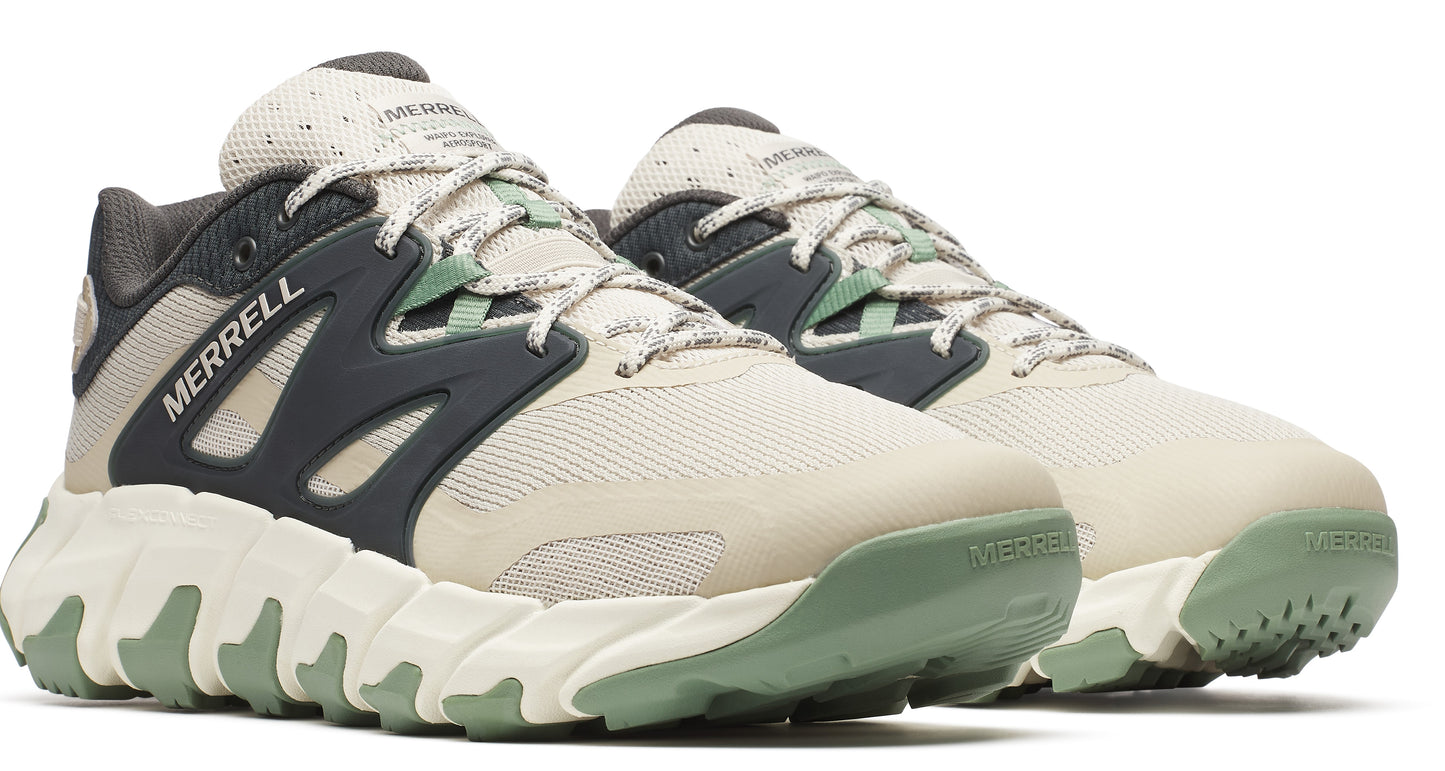 Pair of beige sneakers with dark gray accents and textured green soles, displaying the word "MERRELL" on the side.