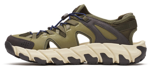 A green, open-toed sandal with dark grey accents on a chunky white and dark grey sole.