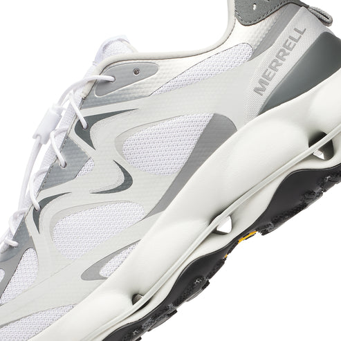 Close-up of a white sneaker with gray accents and the word MERRELL printed on the side, showcasing a sporty design.