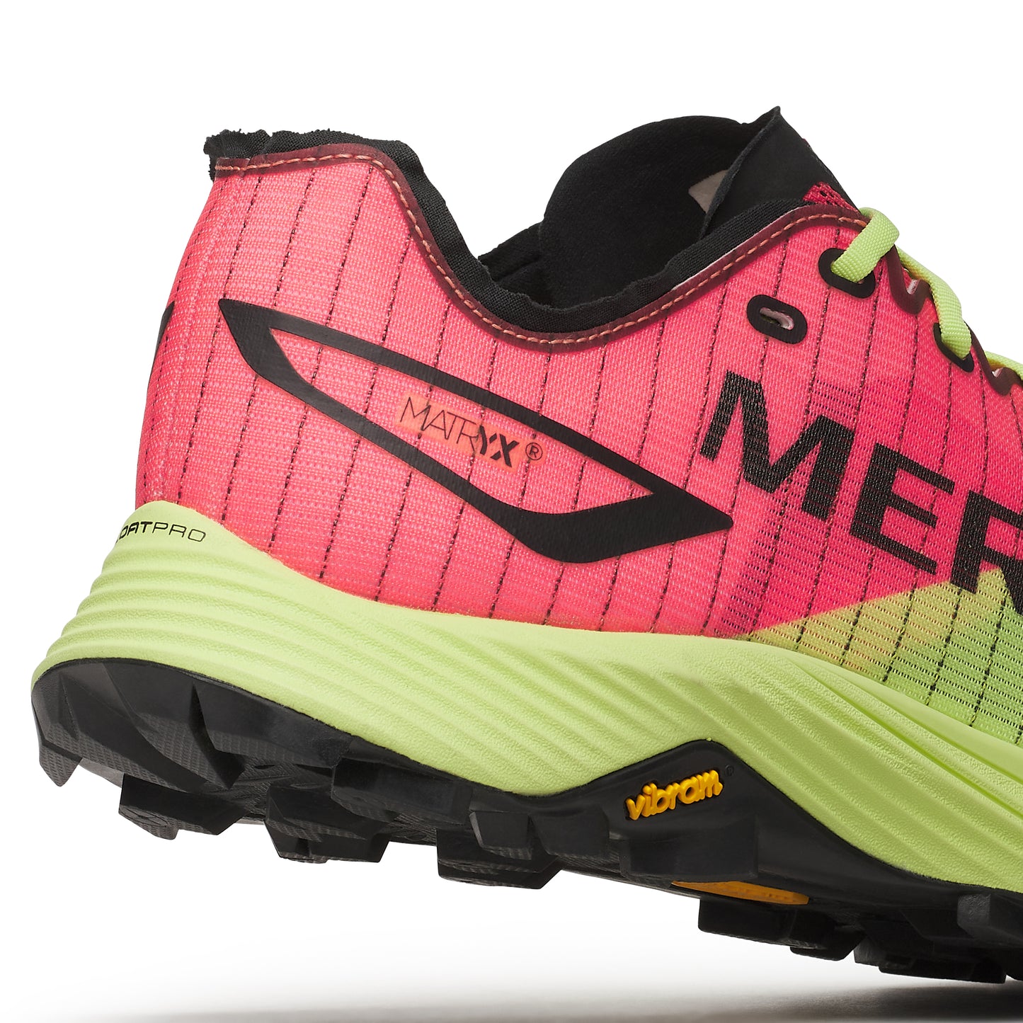 Close up of a red and green running shoe with black accents. The shoe has the word "MER" written on the side and "MATRYX" written near the heel. The sole is yellow, and the tread is black.