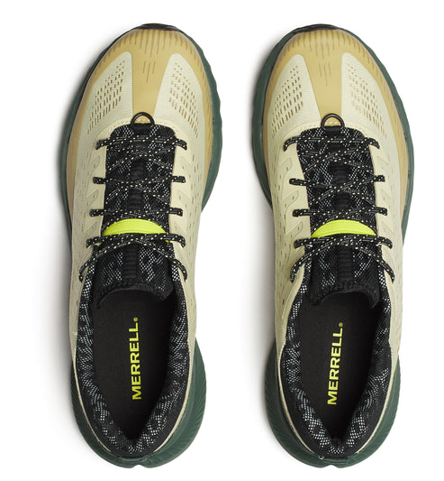 Overhead view of two off-white athletic shoes with black and white patterned laces; the insole shows 'MERRELL'.