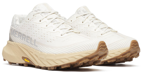 A pair of white running shoes with tan soles and the word MERRELL on the side.
