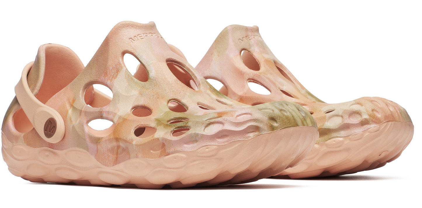 A pair of pink patterned clog-style shoes with holes on a thick, wavy sole.