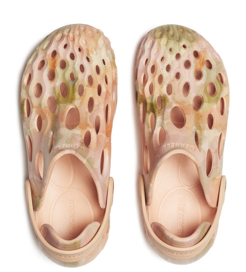 Overhead shot of two light pink and green camouflage clogs with oval-shaped holes.