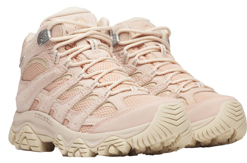 A pair of beige hiking boots with a thick, ridged sole and lace-up closure.