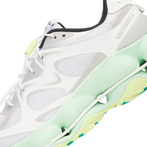 Close-up of a white and light green athletic shoe with the word "MERRELL" visible on the side.