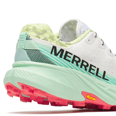 Close-up of a white shoe with neon green and pink soles, and "MERRELL" in black text on its side.