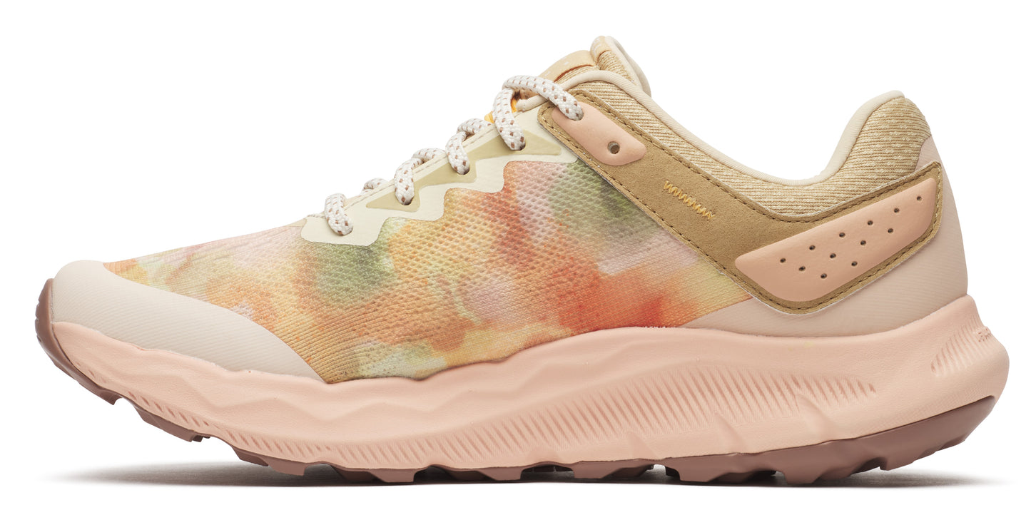 A side-view of a peach-colored shoe with a colorful textile and peach sole.