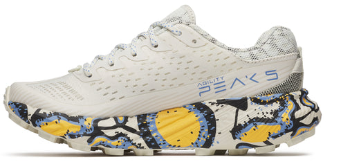 A shoe with white upper, laces, and sole with yellow and blue patterned designs.