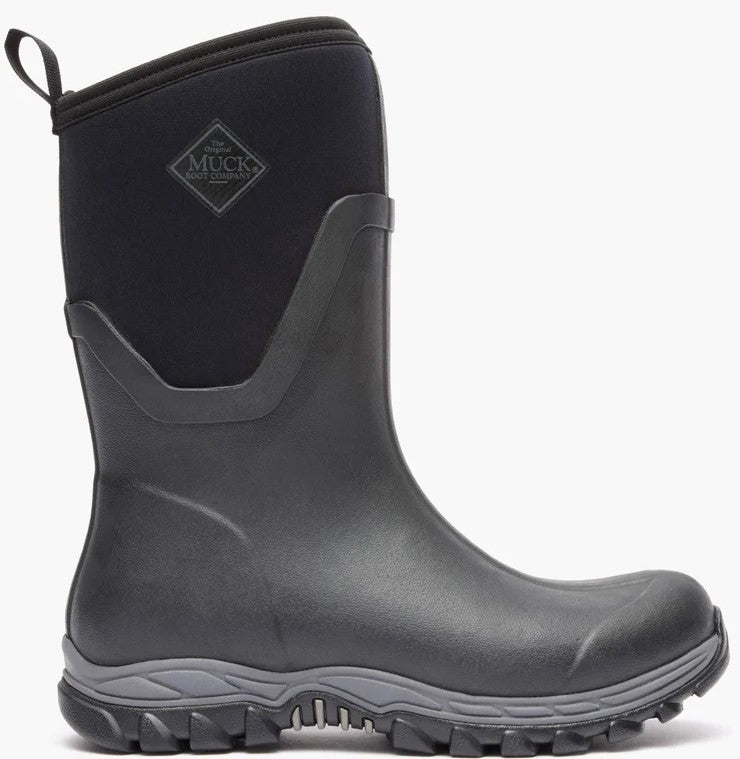 A black mid-calf rubber rain boot with a pull loop at the top, a gray patterned sole, and a visible MUCK BOOT COMPANY logo patch on the upper shaft.