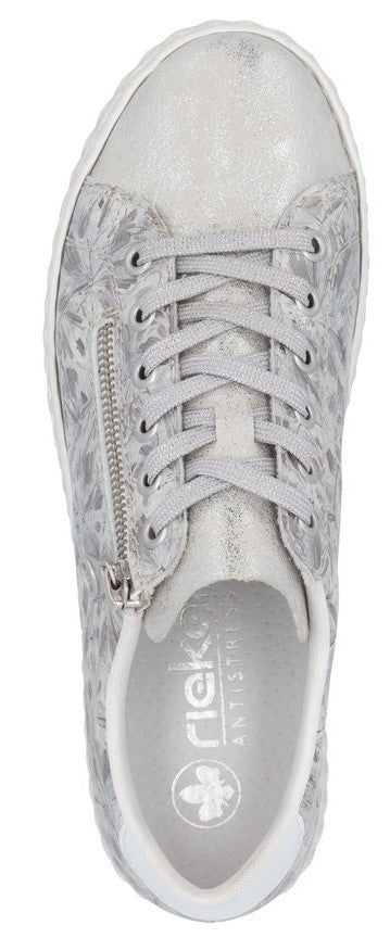 A top-down view of a silver sneaker with floral patterns, laces, and a zipper.