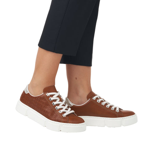 A pair of brown leather shoes with white laces and thick white soles.