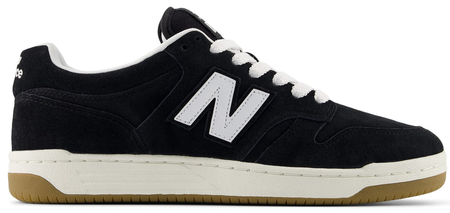 A black suede sneaker with a white N logo on the side, white laces, a white midsole, and a gum rubber outsole.