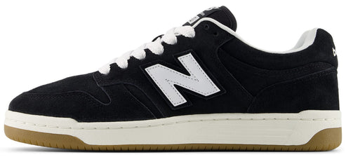 A black suede sneaker with a white N logo on the side, white laces, a thick off-white midsole, and a gum rubber outsole.