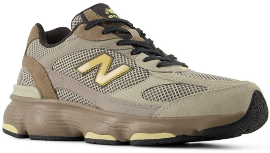A New Balance 9060 sneaker in earth tones featuring mesh and suede overlays, a prominent yellow N logo on the side, dark laces, and a chunky, sculpted midsole in brown and yellow.