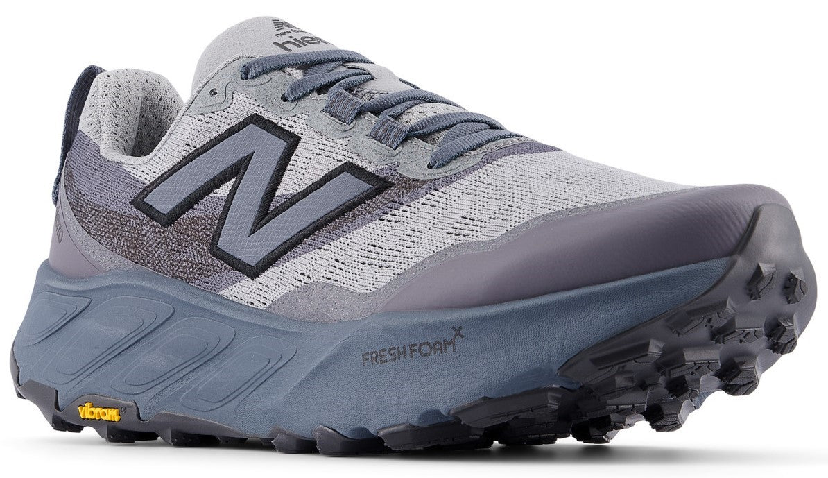 A gray New Balance Fresh Foam X Hiero trail running shoe with a dark gray rugged Vibram outsole, a dark gray N logo on the side, and gray laces, viewed from a side angle.