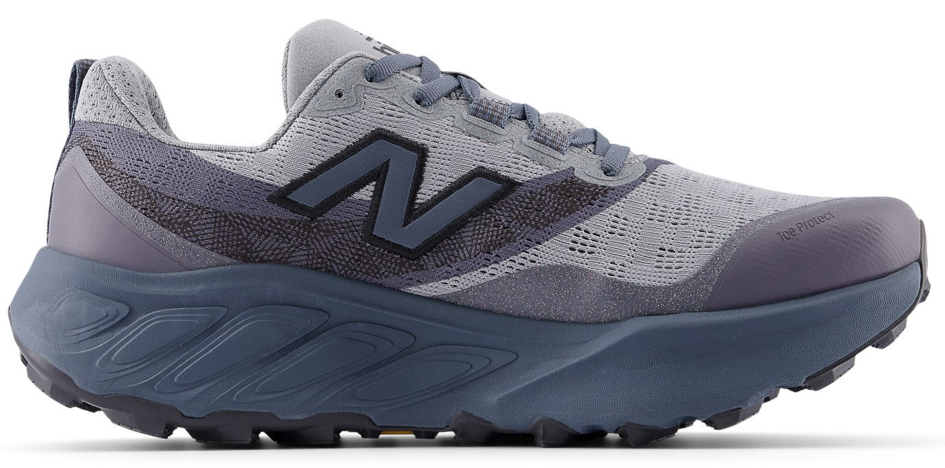 A gray and dark navy trail running shoe featuring a breathable mesh upper, a dark navy logo on the side, a chunky midsole with sculpted lines, and a rugged, high-traction lugged outsole.