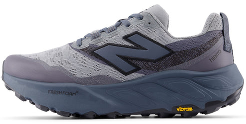 A gray New Balance Fresh Foam X Hierro V8 trail running shoe with a dark blue N logo, a thick blue midsole, and a yellow Vibram logo on the sole.