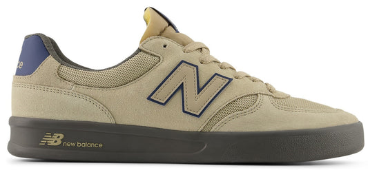 A tan low-top sneaker with a blue "N" logo on the side and a blue heel.