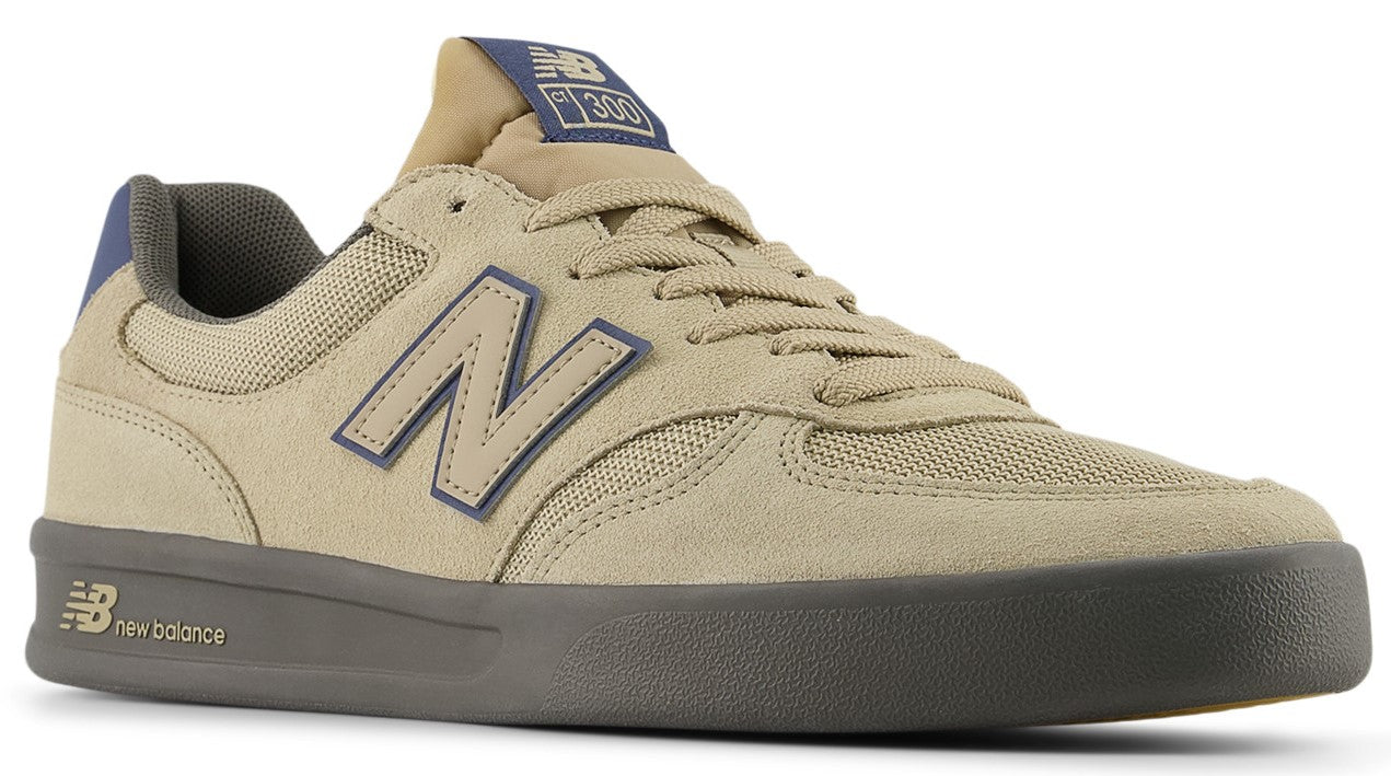 Tan low-top sneaker with a dark gray sole and a navy "N" logo on the side.