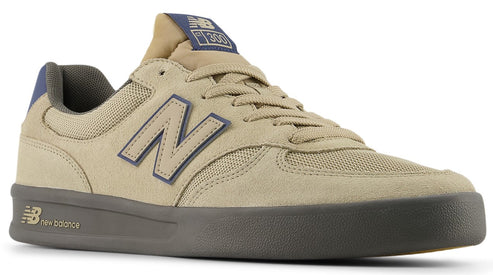 Tan low-top sneaker with a dark gray sole and a navy "N" logo on the side.