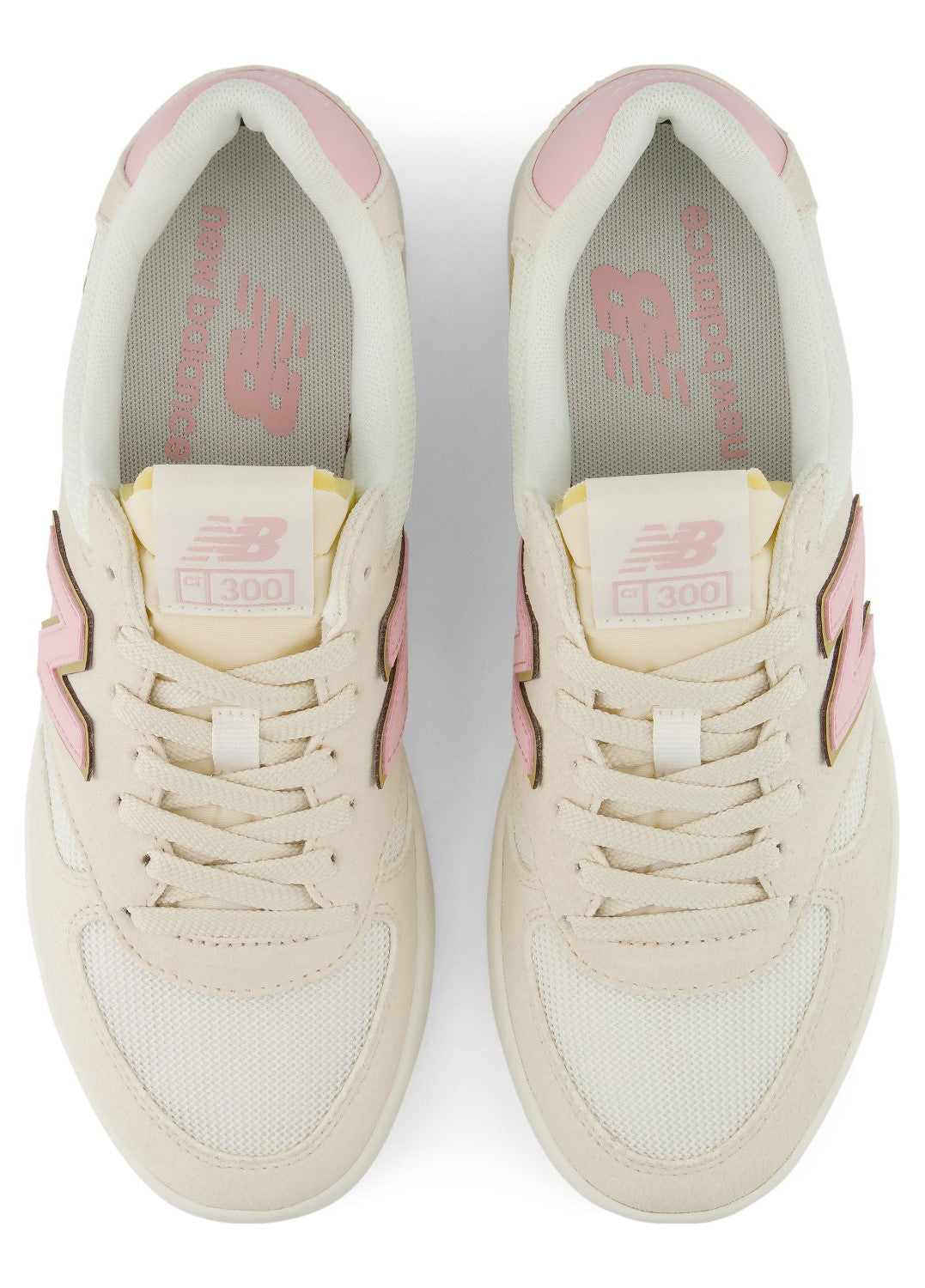A pair of cream-colored New Balance 300 sneakers with light pink accents on the tongue, collar, and side branding, viewed from directly above.