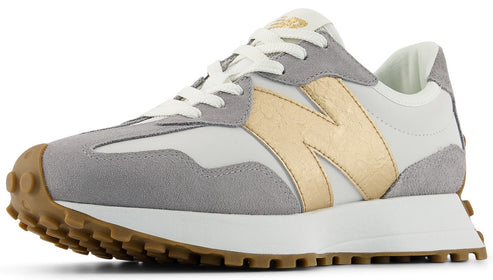 A low-rise sneaker with a white textile upper, grey suede accents, gold logo, white laces, and a brown lug sole.