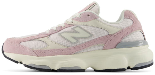 A New Balance athletic shoe with a white mesh upper, light pink suede overlays, an off-white 'N' logo, and a cream-colored foam midsole with gray and black accents.
