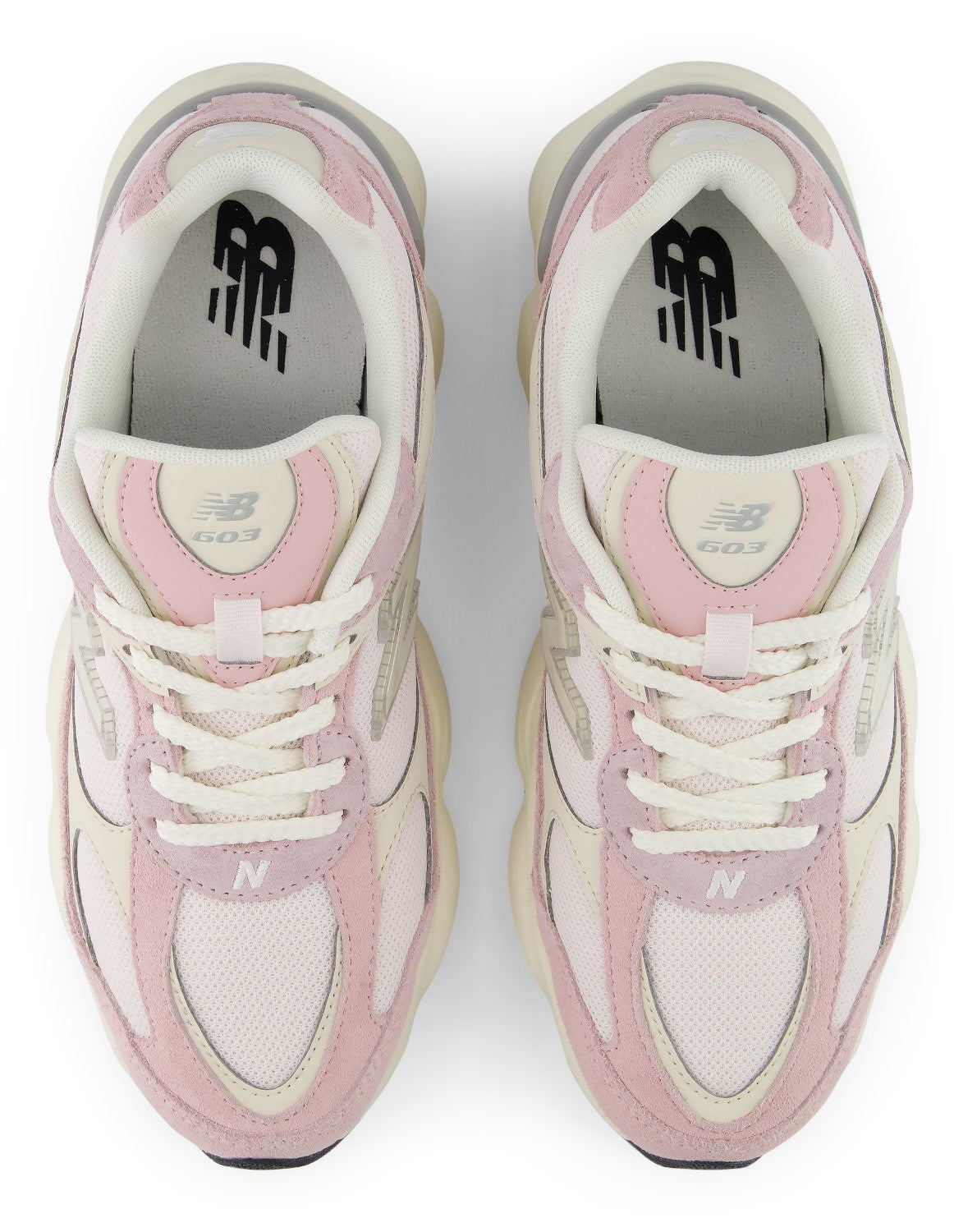A pair of athletic sneakers in shades of light pink and off-white viewed from directly above. The shoes have a chunky, layered design with mesh panels, suede overlays, white laces, and a white NB logo printed on the insole.