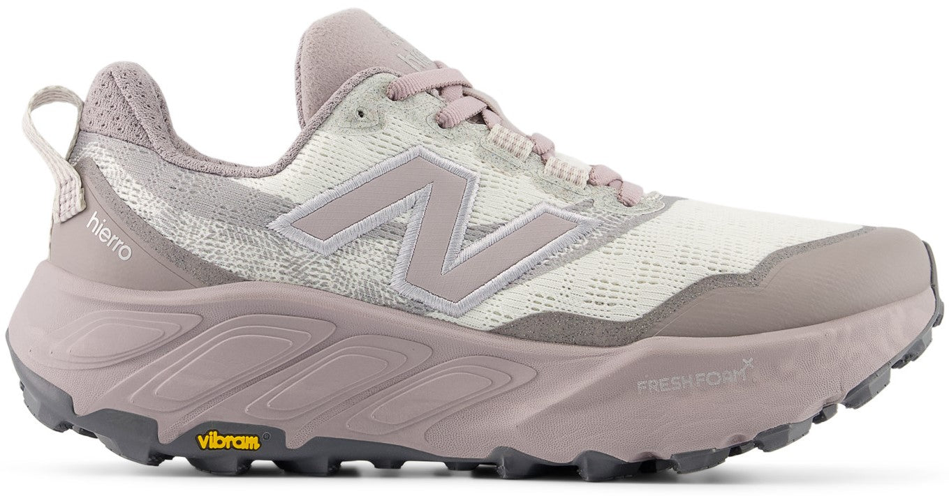 A side view of a women's trail running shoe featuring a cream-colored mesh upper with mauve suede overlays, a thick, sculpted mauve Fresh Foam midsole, and a dark grey Vibram outsole, with 'hierro' and 'Fresh Foam X' branding visible on the side.