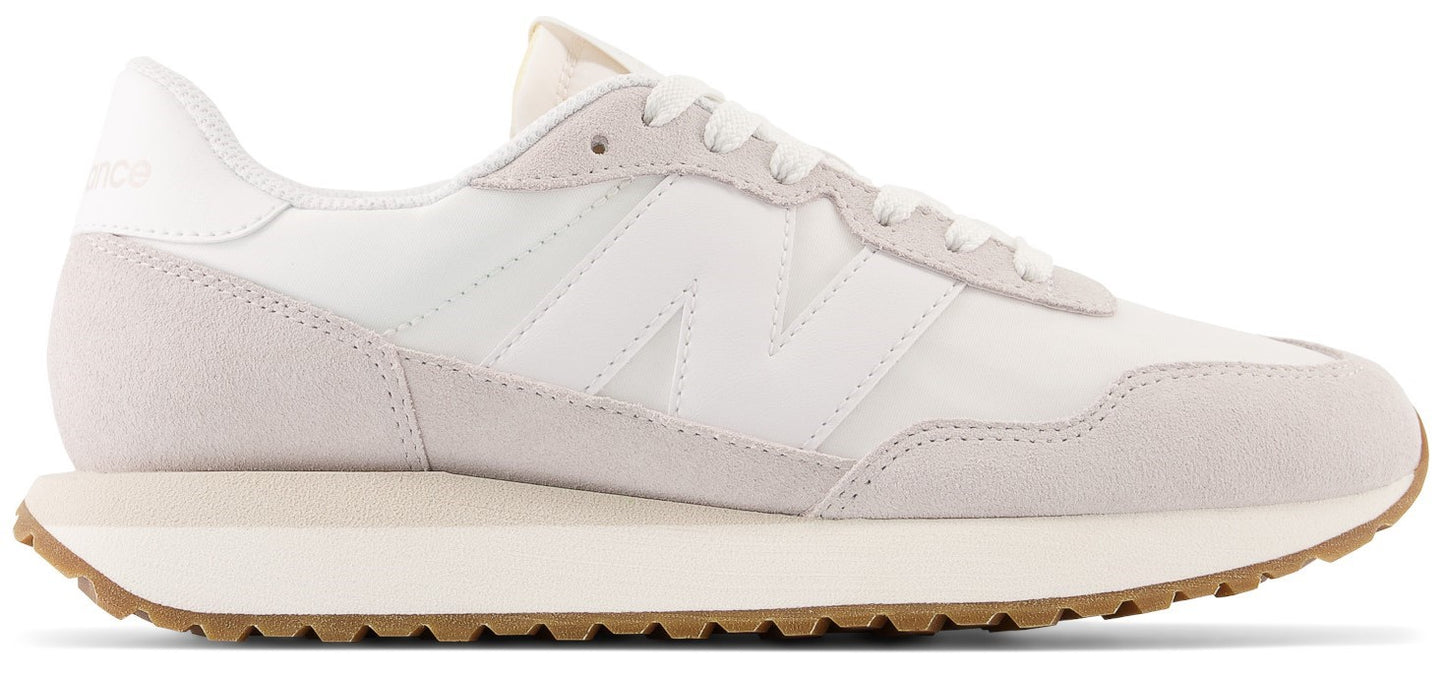 A white sneaker with a beige sole and the letter N on the side.