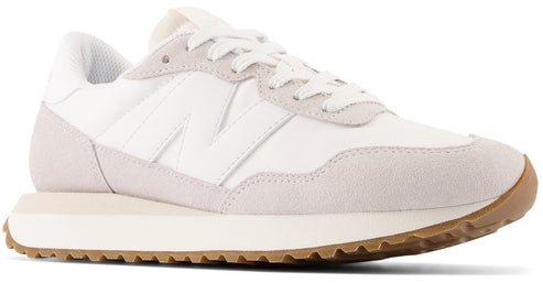 Off-white runner sneaker with white laces, white 'N' logo, and gum sole.
