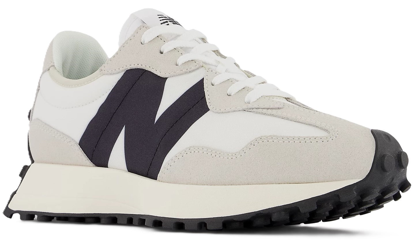 White sneaker with a large black 'N' on the side, suede overlays, and a textured black outsole.