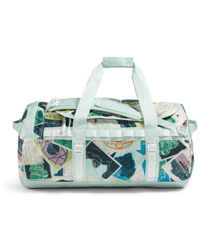 Duffel bag with light blue handles and straps, in a collage of various geometric and organic shapes with dark blue, green, yellow, pink, black and white colors.