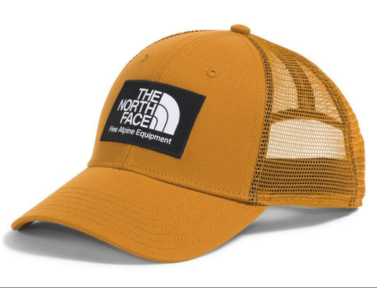 Golden brown baseball cap with a black and white logo patch and mesh sides.