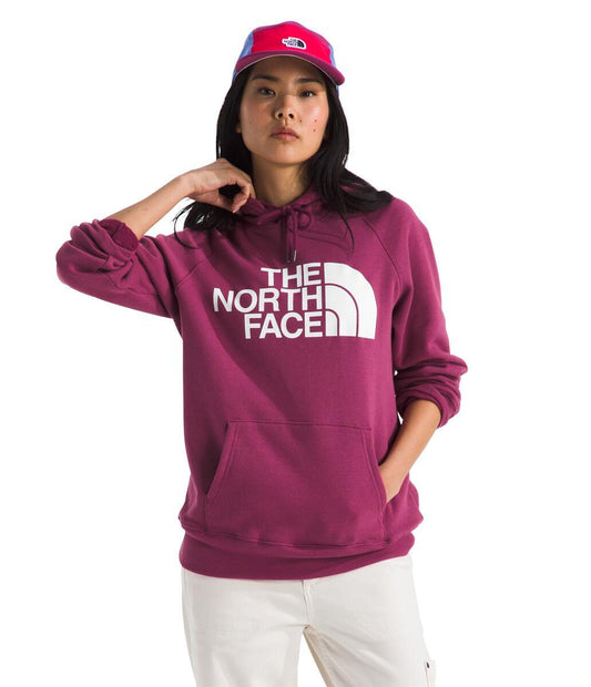 A person wearing a purple hoodie with the words "THE NORTH FACE" printed on it and a red hat.