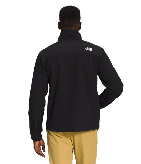 Person wearing black jacket and khaki pants, back view.