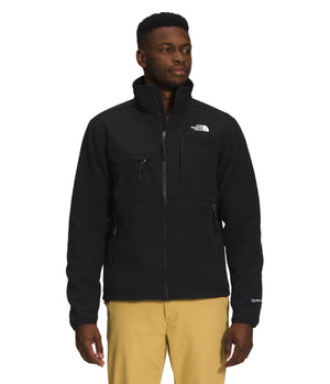 A man wearing a black zippered fleece jacket with white text on the upper right.