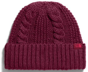 A maroon-colored cuffed beanie with a cable-knit pattern on the crown and a ribbed pattern on the brim, featuring a small tag with The North Face logo on the lower right side.