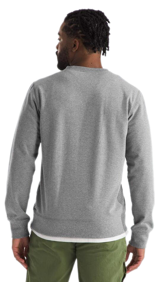 Back view of a man with dark hair wearing a long sleeve grey shirt and green pants.