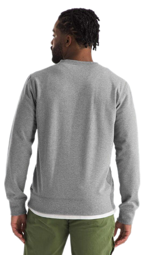 Back view of a man with dark hair wearing a long sleeve grey shirt and green pants.