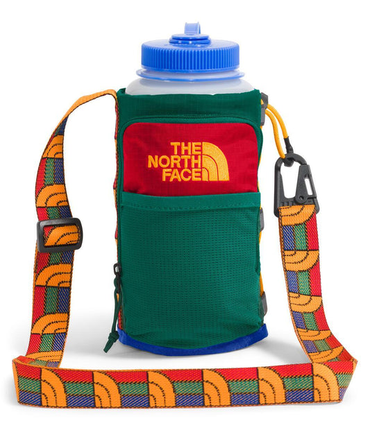 Green and red water bottle with blue lid and colorful strap.