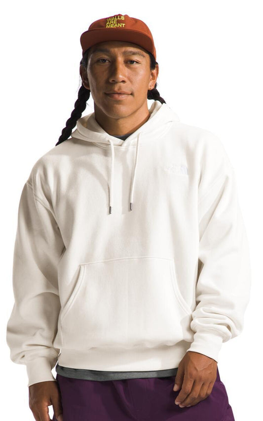 Person in a white hoodie and orange baseball cap with text, long braids visible.